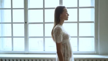 Moda. Güzel kadın zarif beyaz elbisenin içinde poz