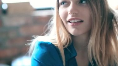 Evdeki yatakta kameraya poz veren bir kadın. 