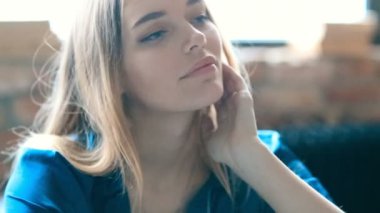 Genç ve güzel bir kadın evde dinleniyor. 