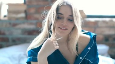 Genç ve güzel bir kadın evde dinleniyor. 