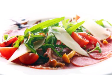 Biftek carpaccio roka ve mantarla servis edilir.