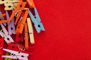 Kırmızı arka plandaki küçük renkli ofis mandallarının yakın plan görüntüsü