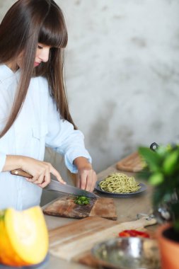 Yemek pişirmek. Kız mutfakta yemek pişiriyor.