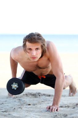 genç ve yakışıklı bir adam sahilde Fitness egzersizleri yapıyor