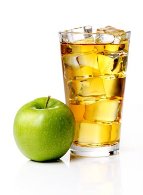 İçi buz dolu bir bardak ferahlatıcı elma suyu ve cam kenarında yeşil bir elma.