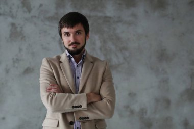 Palto giyen yakışıklı adamın stüdyo portresi.