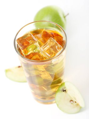 Bir bardak buzlu elma suyu ve beyaz arka planda duran elmalar.