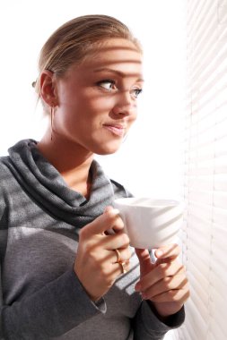 güzel bir kadın ile bir pencere yanında kahve gri kazak