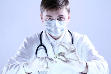 Doktor elinde şırınga tutuyor.