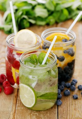 Tahta bir masada pipetle üç farklı soğuk içecek.