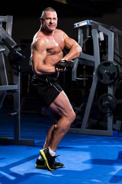 Yakışıklı kaslı adam spor salonunda çalışıyor.