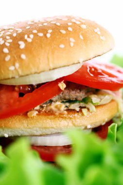 Salata yapraklarının üzerinde büyük ve lezzetli bir burger.