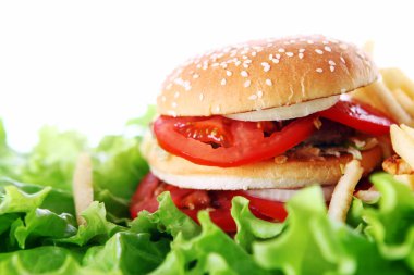 Salata yapraklarının üzerinde büyük ve lezzetli bir burger.