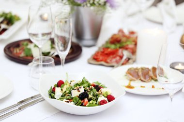 Ziyafette farklı sebzelerle lezzetli salata ve diğer yiyecekler.