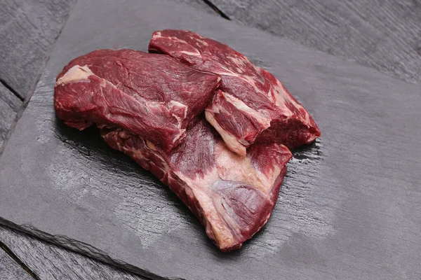 Frisches Fleisch Auf Einem Schwarzen Schneidebrett — Stockfoto