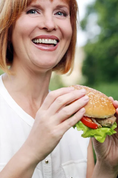 Retrato Uma Mulher Atraente Que Está Comendo Hambúrguer Parque — Fotografia de Stock