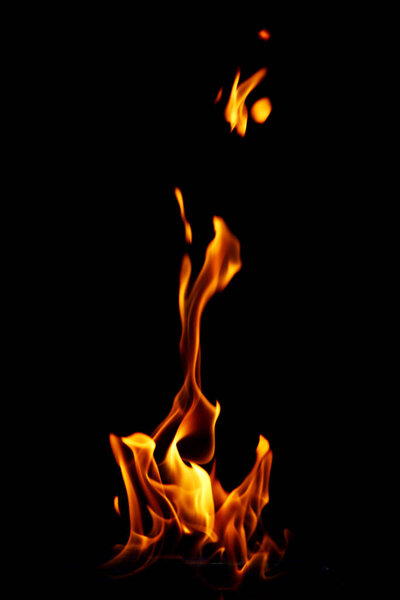 Glowing fire flame over black background