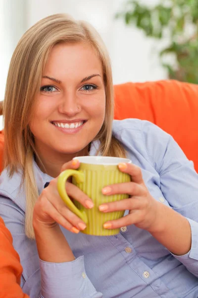 Young Blond Caucasian Woman Smiling Mug Orange Sofa — Stock Photo, Image
