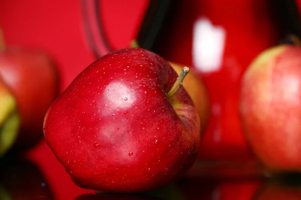 Maçãs Jarro Com Suco Contra Fundo Vermelho — Fotografia de Stock