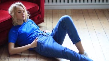 Genç ve güzel bir kadın evde dinleniyor. 