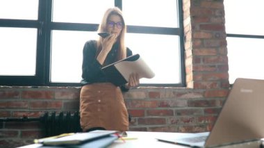 İş kadını ofiste akıllı telefondan konuşuyor.