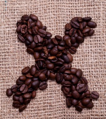 Kahve çekirdekleri kumaş çuvalının üstünde.
