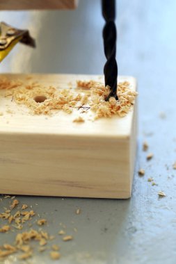 Matkapla delinen ve ölçülen ahşap bir çubuğun yakın plan fotoğrafları.