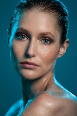 güzel bir kız ıslak deri ile mavi bir arka plan üzerinde poz