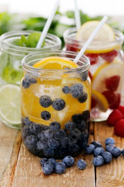 Tahta bir masada pipetle üç farklı soğuk içecek.