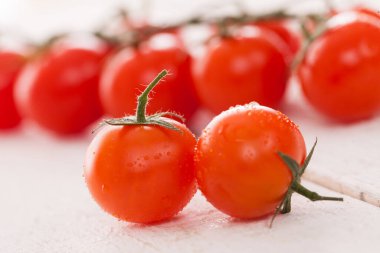 Beyaz ahşap yüzeyde taze kiraz domatesleri. 