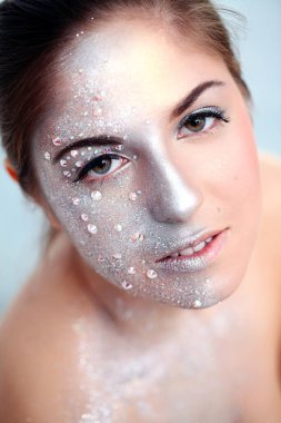 Beyaz bir arka plan üzerinde gümüş beden sanatı ile güzel bir kızın portresi