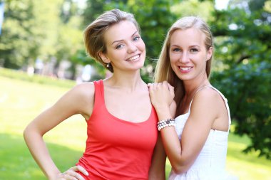 hoş çok eğlendiği parkta iki kız portresi. Onlar konuşuyor, tartışıyor, birbirlerine gülüyor ve gerçekten iyi eğlenceler