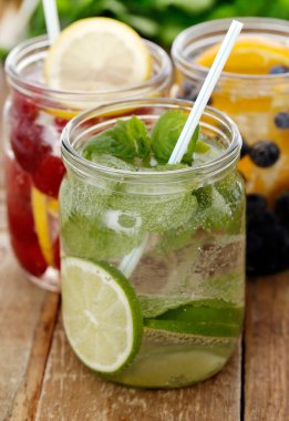 Tahta bir masada pipetle üç farklı soğuk içecek.