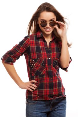 Kare gömlekli ve güneş gözlüklü çekici bir kadın.