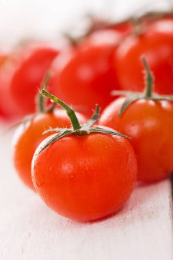 Beyaz ahşap yüzeyde taze kiraz domatesleri. 