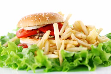 Salata yapraklarında ateş olan büyük ve lezzetli bir hamburger.