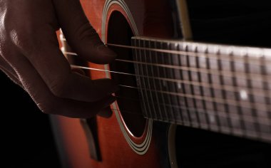 Akustik gitarda çalan müzisyen