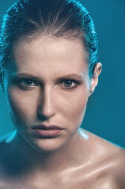 güzel bir kız ıslak deri ile mavi bir arka plan üzerinde poz