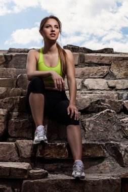 Formalı güzel bir kadın eski taş tuğlalarda dinleniyor.