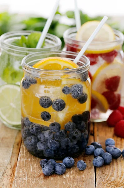 Tahta bir masada pipetle üç farklı soğuk içecek.