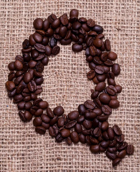 Kahve çekirdekleri kumaş çuvalının üstünde.