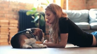 Evde köpekle oynayan güzel genç bir kadın.
