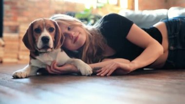 Evde köpekle oynayan güzel genç bir kadın.