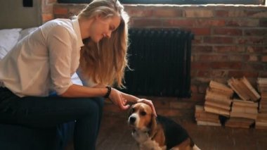 Evde köpekle oynayan güzel genç bir kadın.