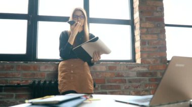 İş kadını ofiste akıllı telefondan konuşuyor.