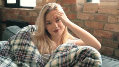 Genç ve güzel bir kadın evde dinleniyor. 