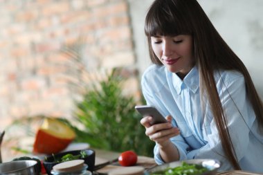 Yemek pişirmek. Kız mutfakta yemek pişiriyor.