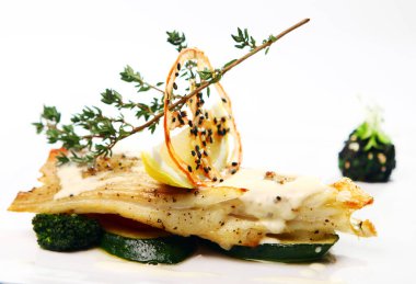 Gurme usulü ızgara balık, sebzeli ve yeşil tabakta.