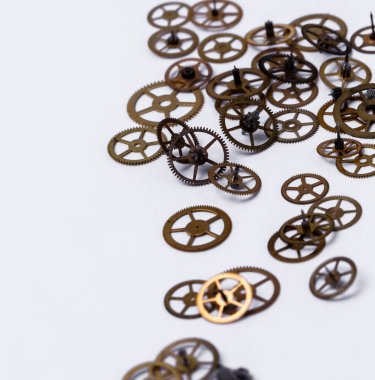 Detaylar, teknoloji. Beyaz arkaplanda küçük dişliler yığını