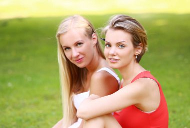 hoş çok eğlendiği parkta iki kız portresi. Onlar konuşuyor, tartışıyor, birbirlerine gülüyor ve gerçekten iyi eğlenceler